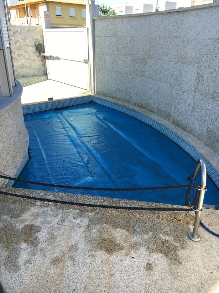 Cobertor térmico, confeccionado en un tejido de burbujas que mantiene constante la temperatura del agua de la piscina.